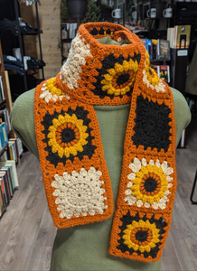 Crochet Scarf. Sunflowers on black and white with orange trim