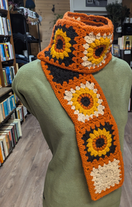 Crochet Scarf. Sunflowers on black and white with orange trim